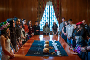Sanlågu CHamorus gather around the ancestral human remains of four CHamoru “Matua” and sing “Malak Na Pution Tåsi" during a moving ceremony March 6 at the American Museum of Natural History in New York City. The museum released the three skulls and a mandible believed to be the ancestors of the CHamoru people that were removed from Hagåtña by P. Tubino and delivered to German anthropologist Felix von Luschan around 1878. After the ceremony Guam State Historic Preservation Officer Patrick Lujan carefully packed the remains and hand-carried them to Guam, bringing them home 150 years later. Copyright photo by Manny Crisostomo